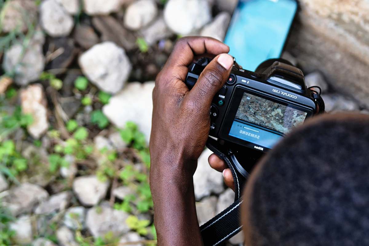cell phone person taking a photo of Samsung smartphone using DSLR camera computer